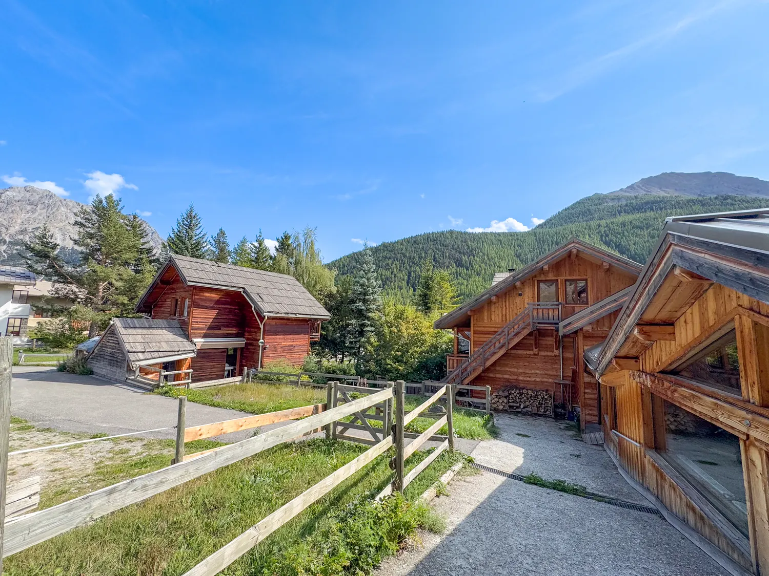 Vue d'ensemble des trois chalets du domaine et de l'allée d'accès