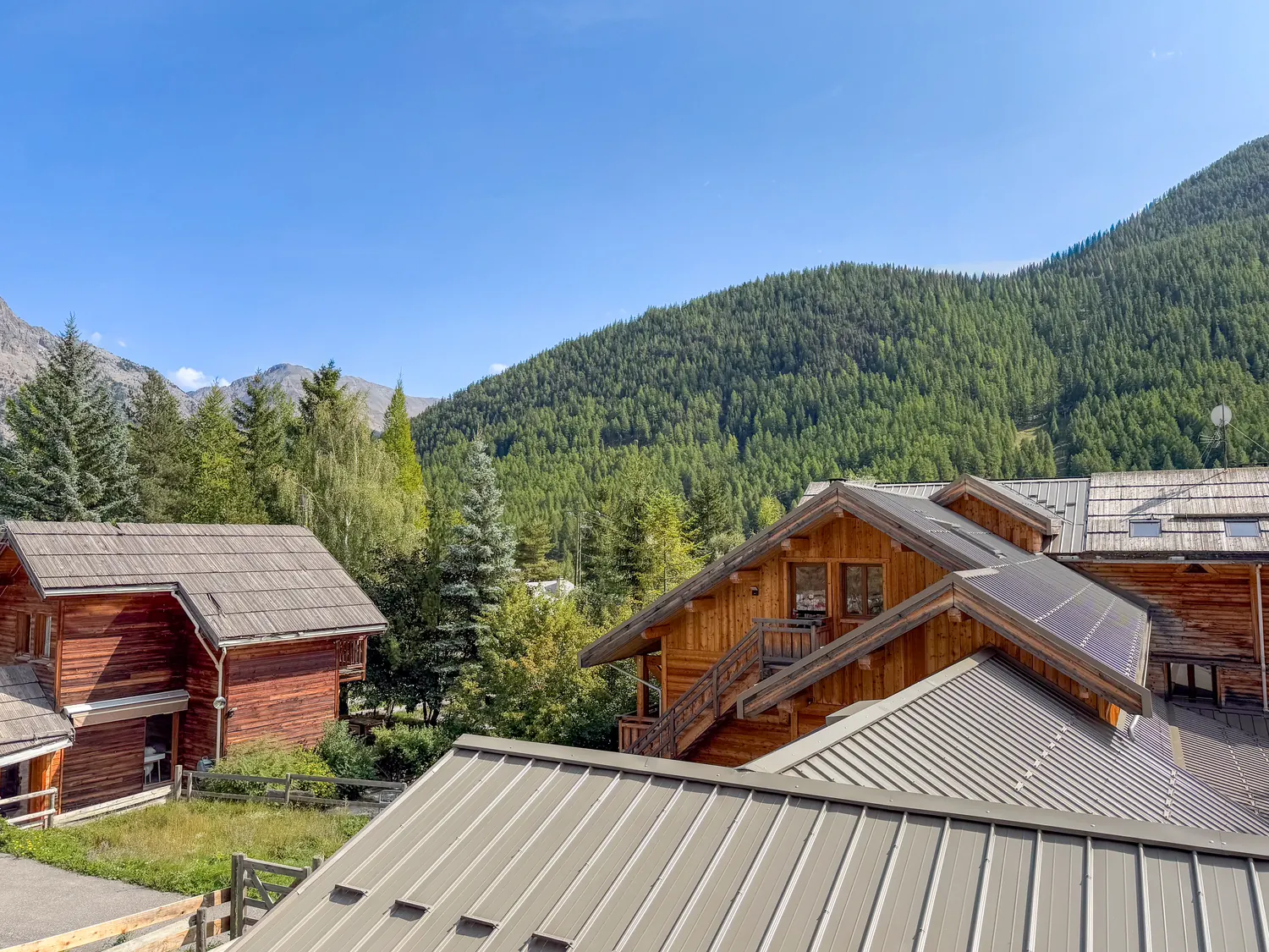 Vue surélevée du domaine : les trois chalets et leurs terrasses
