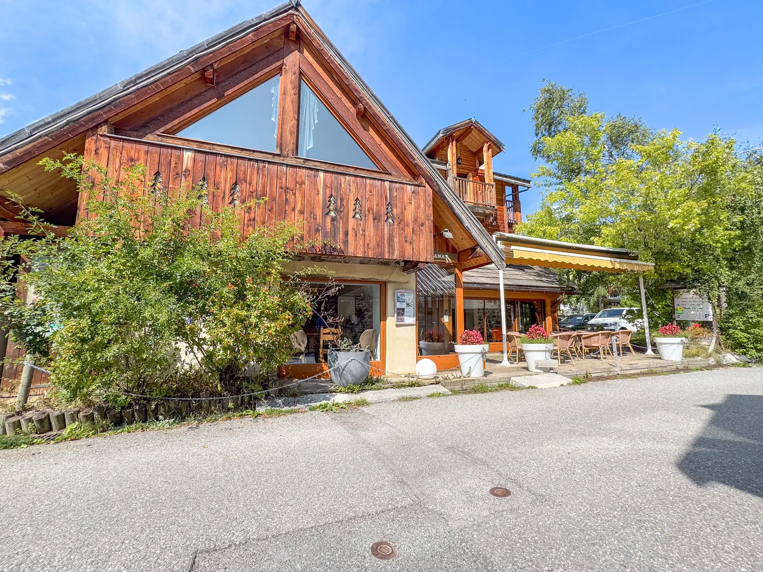 Façade en bois et pierre du domaine, pignon ajouré et tourelle