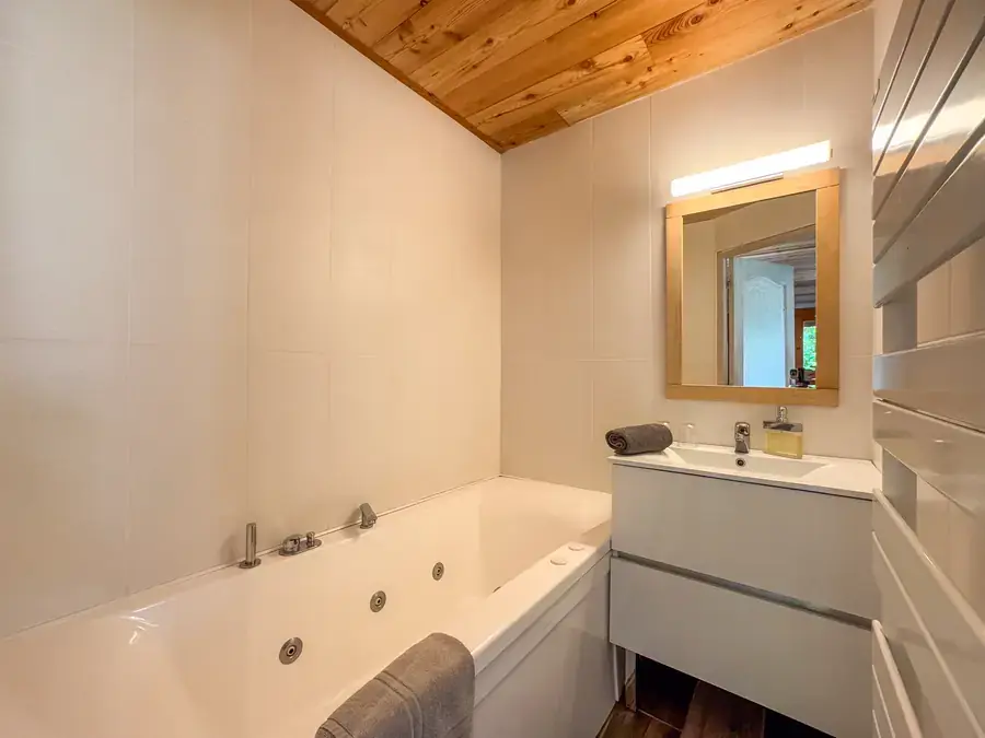 Salle de bains avec baignoire balnéo et miroir rétroéclairé