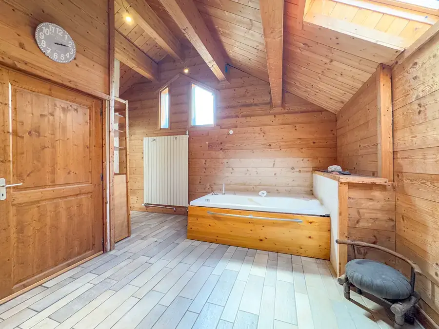 Salle de bains avec baignoire encastrée et plafond cathédrale
