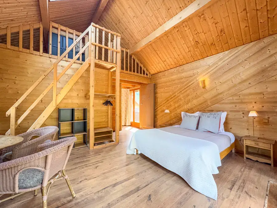 Suite avec mezzanine et plafond cathédrale en bois