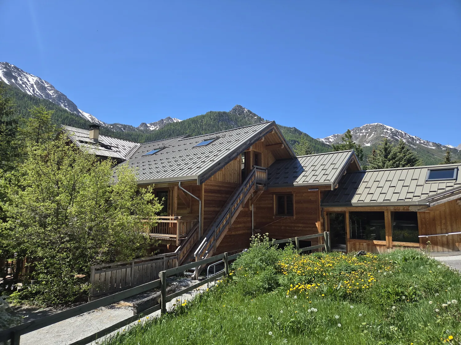Façade en bois du domaine et sommets enneigés — La Joie de Vivre, Névache